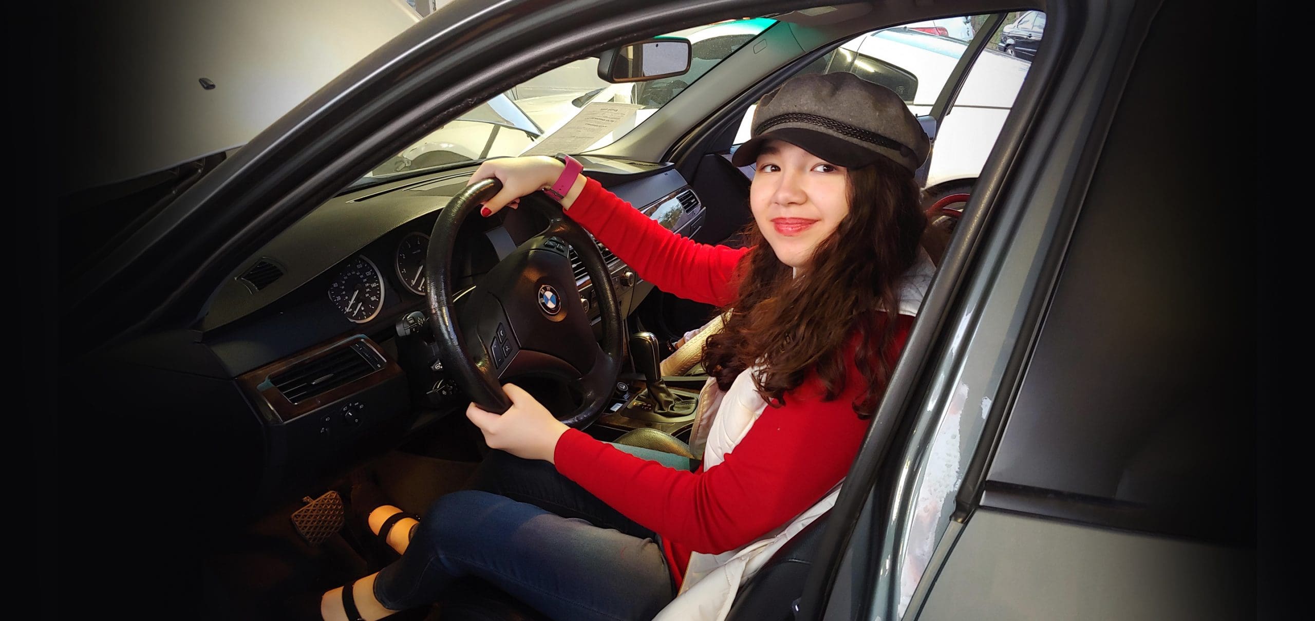 Woman behind car steering wheel