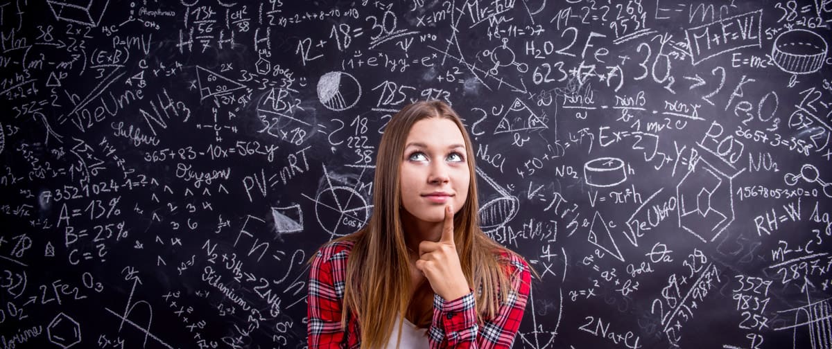 Student against a big blackboard with mathematical symbols