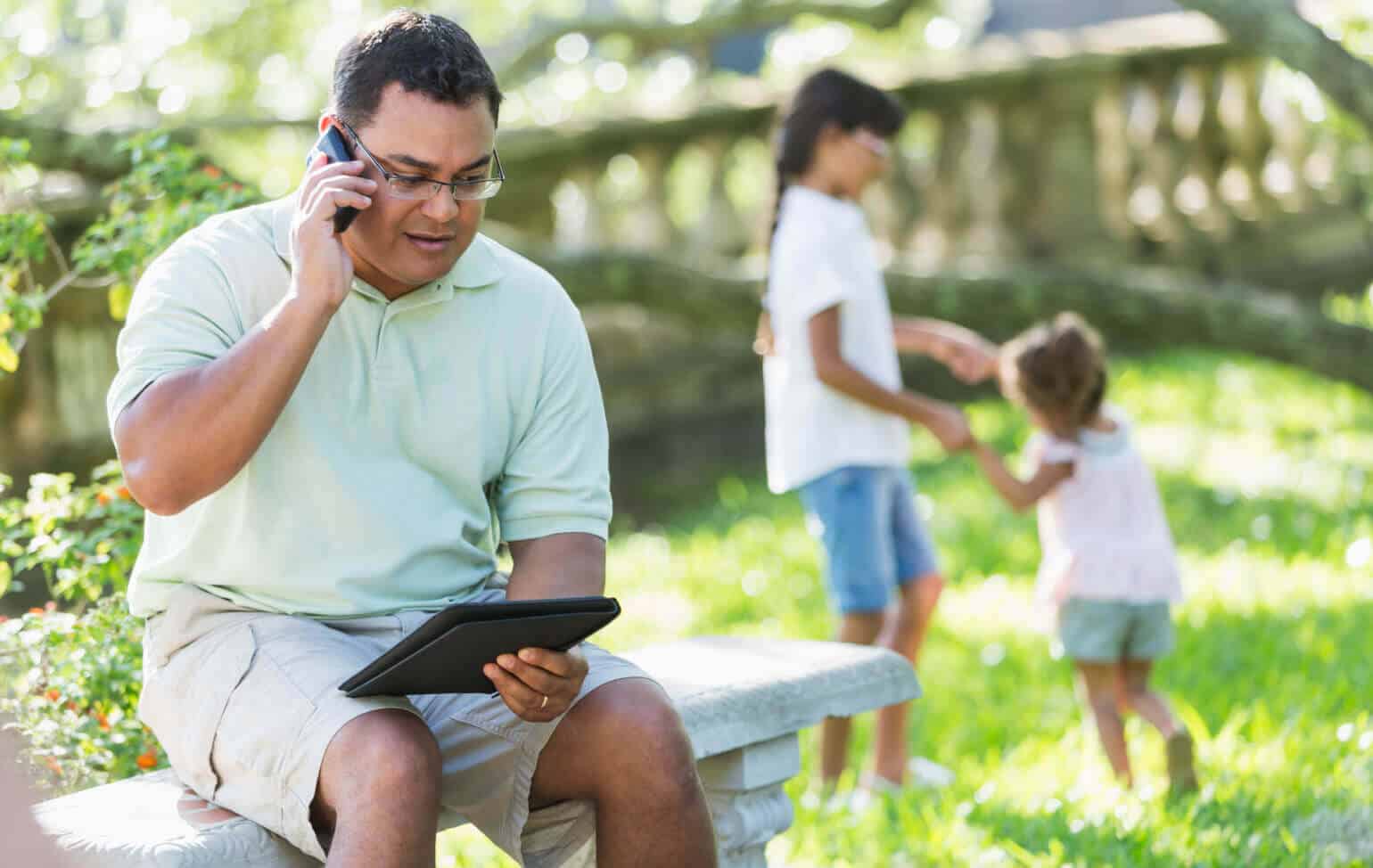 Parent on a phone call while children play